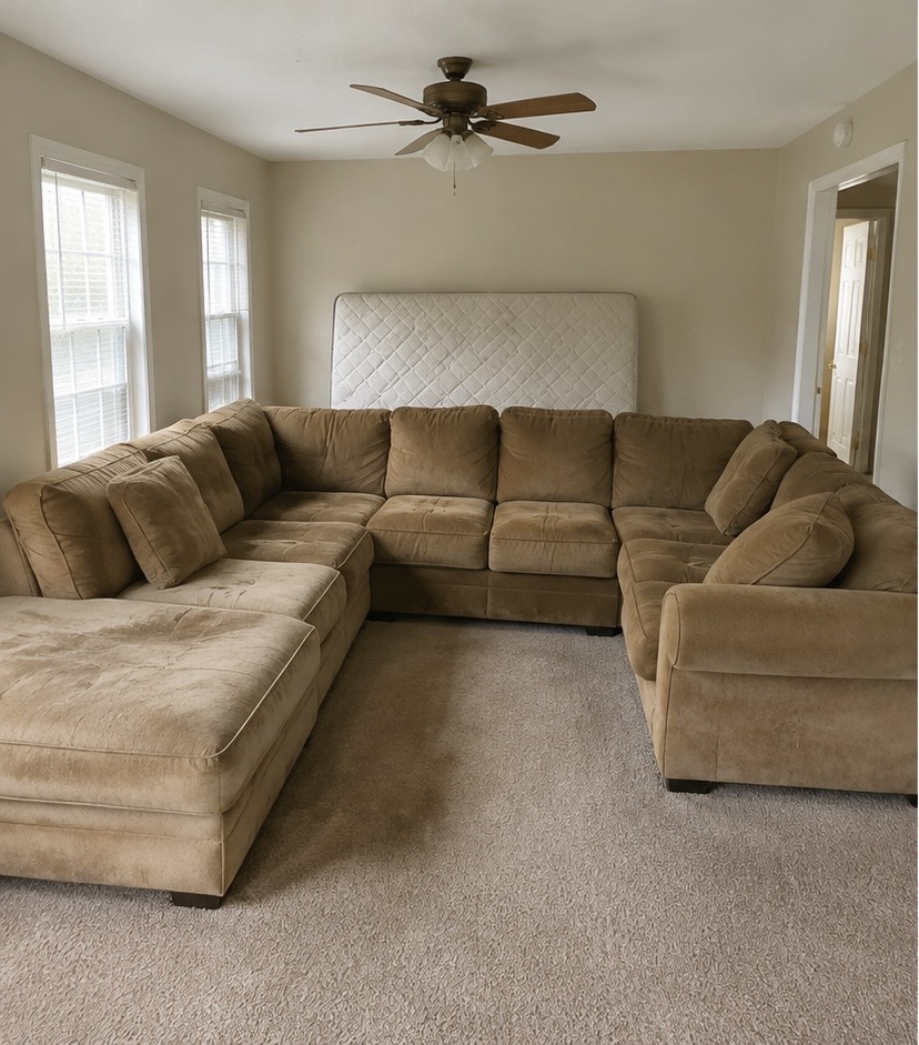 Old sectional sofa and mattress in a living room before removal